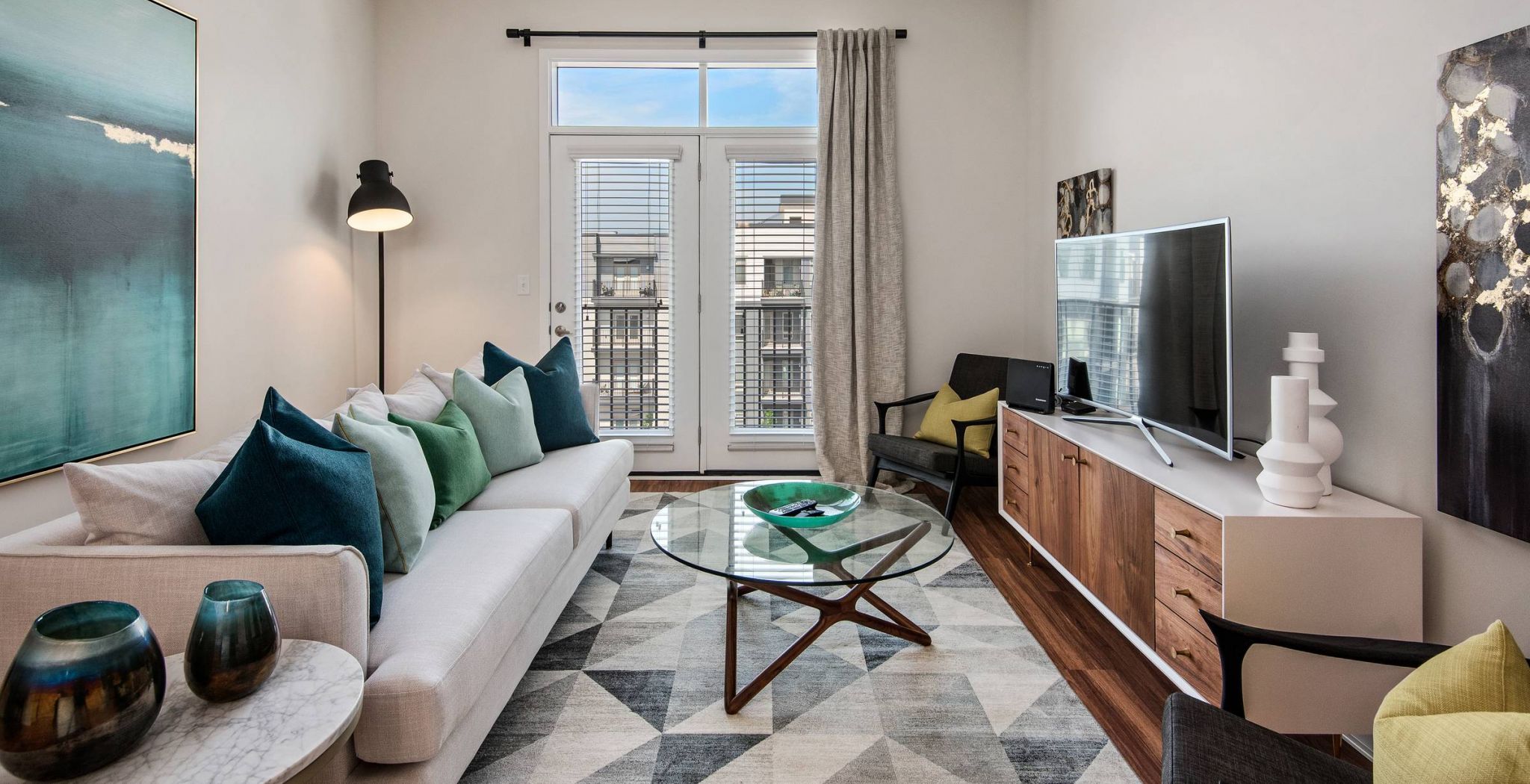 Avenue 80 apartments in Overland, KS cozy living room area with large glass door to private balcony.
