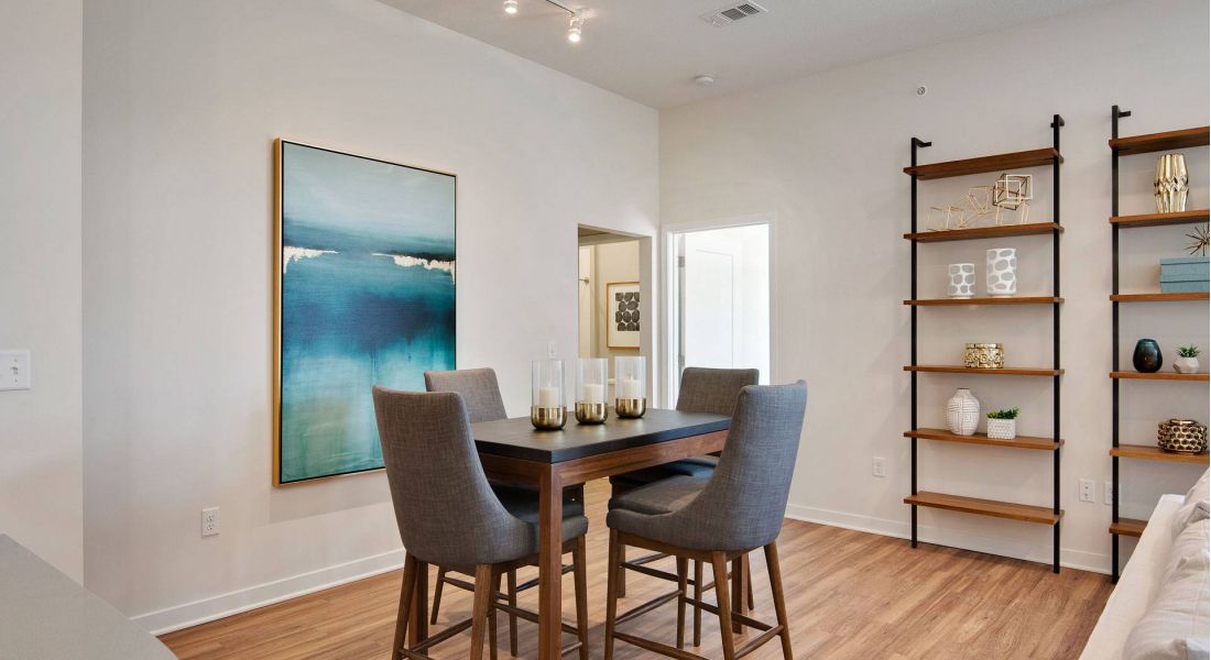 Avenue 80 apartments in Overland, KS dining area with wood flooring, high ceilings, and stylish light fixtures.